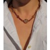 Hexagonal flat beads of rutilated quartz in symmetrical pattern and larger faceted round bead in the center of the necklace.