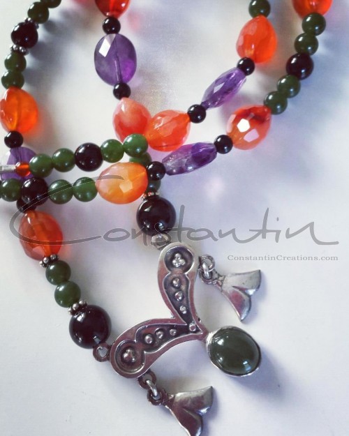 Vintage handmade silver pendant, on a multicolor gemstone necklace.