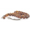 The amber beads are initially shaped and curved with spiral pattern details.